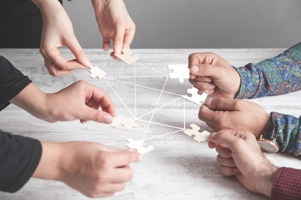 hands-people-holding-jigsaw-puzzle-connection-partnership-success-teamwork (1)